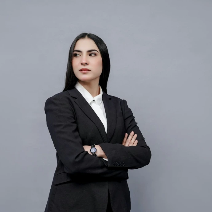 a woman in a business suit with her arms crossed